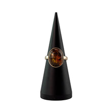 Load image into Gallery viewer, "Amber Oval Ring on a black stand with a white background," - Down to Earth.