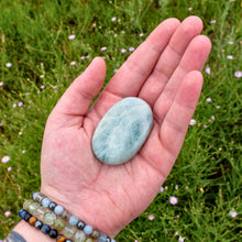 Load image into Gallery viewer, "Open hand holding a standard Aquamarine palm stone," - Down to Earth.