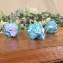 Load image into Gallery viewer, Blue Aura Quartz Point side facing on a style background - Down To Earth