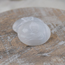 Load image into Gallery viewer, Buddha Engraved Selenite Palm Stones on a wooden surface - Down to Earth