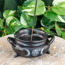 Load image into Gallery viewer, "Cauldron Incense Holder on a wooden plank with green foliage in the background," - Down to Earth.