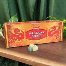 Load image into Gallery viewer, "Box of HEM Dragons Blood incense sticks on a wooden surface with greenery in the background," - Down to Earth.