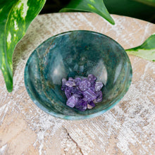 Load image into Gallery viewer, Small Green Moss Agate Bowl on a wooden surface with amethyst chips inside top angle styled photo - Down to Earth