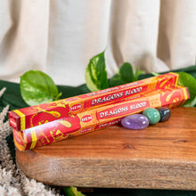 Load image into Gallery viewer, "Hem Dragons Blood incense sticks on a wooden surface with green leaves in the background," - Down to Earth.