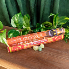 Load image into Gallery viewer, "Two 20pk packages of HEM Incense Sticks on a wooden surface with green foliage in the background," - Down to Earth.