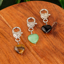 Load image into Gallery viewer, Crystal Heart Pet Pendants group photo on a wooden surface - Down to Earth