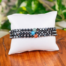Load image into Gallery viewer, Hematite with Crystal Bead Stretch Bracelet on a white pillow sitting on a wooden surface - Down to Earth