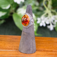 Load image into Gallery viewer, Honey Amber Oval Ring angled front side with plants displayed on a styled background - Down To Earth