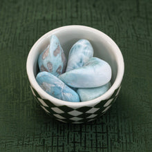 Load image into Gallery viewer, Tumbled Larimar in a bowl on the surface of a green cloth - Down to Earth