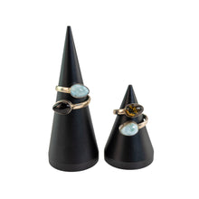 Load image into Gallery viewer, "Two black cone stands with Larimar & Amber Sterling Silver rings on them on top of a white background," - Down to Earth.