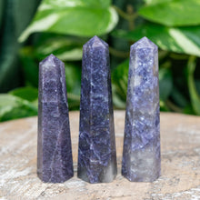 Load image into Gallery viewer, "Three Lepidolite Towers on a wooden base with green foliage in the background. Due to the lithium contents of Lepidolite, it is widely used in the metaphysical community to manage emotions," - Down to Earth.