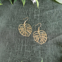 Load image into Gallery viewer, Monstera Leaf Earrings top down displayed on a styled background - Down to Earth