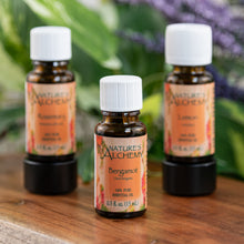Load image into Gallery viewer, Nature’s Alchemy Essential Oil on a wooden surface - Down to Earth