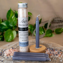Load image into Gallery viewer, "A styled photograph of a Stress Less Ritual Bath Kit. This includes four lavender chime candles, a wooden candle holder and 100mg of bath salts." - Down to Earth.