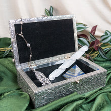 Load image into Gallery viewer, "Decorative Silver OM Box with a necklace and other items inside on a green fabric background," - Down to Earth.