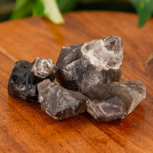 Load image into Gallery viewer, Smoky Chevron Amethyst Raw on a wooden surface close up - Down to Earth