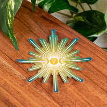 Load image into Gallery viewer, "Single Triple Moon Crystal Holographic Sticker on a wooden base with green foliage in the background," - Down to Earth.