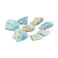 Load image into Gallery viewer, "Side angle of a collection of eight raw aquamarine crystals against a white background," - Down to Earth.