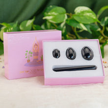 Load image into Gallery viewer, "A four-piece black obsidian yoni egg set within a light pink box, propped up against the lid," - Down to Earth.