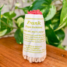 Load image into Gallery viewer, "Rope incense package labeled 'Frank' on a wooden surface with green leaves in the background," - Down to Earth.