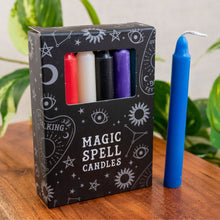 Load image into Gallery viewer, "Box of 'Magic Spell Candles' with colorful candles inside, one blue candle on a wooden surface," - Down to Earth.