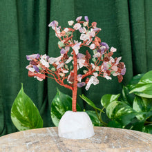 Load image into Gallery viewer, "Mixed Crystal Chip Tree on a wooden plank with green foliage in the background," - Down to Earth.