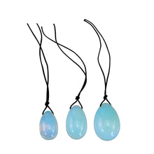 Load image into Gallery viewer, "Three opalite yoni eggs ranging from small to large with black string tied to the top. These crystals are used in Kegel exercises to strengthen the pelvic floor," - Down to Earth.