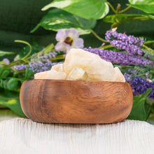 Load image into Gallery viewer, "Wooden bowl overflowing with raw citrine pieces and flowers in the background," - Down to Earth.