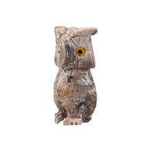 Load image into Gallery viewer, "Stone sculpture in the shape of an owl with yellow eyes against a white background," - Down to Earth.