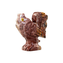 Load image into Gallery viewer, "Small stone figurine of a rooster that has yellow eyes against a white background," - Down to Earth.