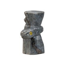 Load image into Gallery viewer, "Stone sculpture in the shape of a snake wrapped around a wooden pillar with yellow eyes against a white background," - Down to Earth.