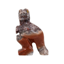 Load image into Gallery viewer, "A stone-carved figurine in the shape of a t-rex with yellow eyes against a white background," - Down to Earth.