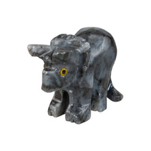 Load image into Gallery viewer, "A grey marbled stone carving of a triceratops with yellow eyes against a white background," - Down to Earth.