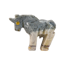 Load image into Gallery viewer, "Left side of a stone-carved figurine in the shape of a unicorn with yellow eyes against a white background," - Down to Earth.