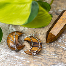 Load image into Gallery viewer, Staged shot of a wire-wrapped tiger's eye moon pendant. - Down to Earth.