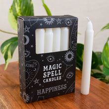 Load image into Gallery viewer, "Box of 'Magic Spell Candles Happiness' on a wooden surface with a white candle beside it," - Down to Earth.