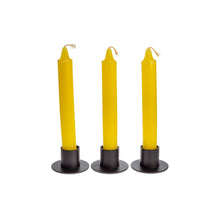 Load image into Gallery viewer, Front view of three yellow ritual candles standing upright in black metal candle holders. - Down to Earth.