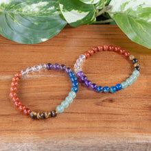Load image into Gallery viewer, 6mm 7 Chakra Healing Bracelet top down displayed on a stand displayed on a styled background - Down to Earth
