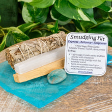 Load image into Gallery viewer, "Amazonite Smudging Kit that includes a White Sage bundle, a 4'' Selenite wand, Palo Santo, a blue organza bag, and tumbled Amazonite," - Down to Earth.
