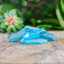 Load image into Gallery viewer, Aqua Aura Quartz Crystal Point on a wooden surface low angle styled photo - Down to Earth
