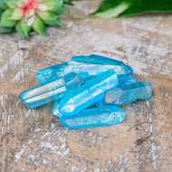 Aqua Aura Quartz Crystal Point on a wooden surface high angle styled photo - Down to Earth