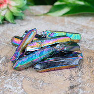 Rainbow Aura Quartz Crystal Point on a wooden surface high angle styled photo - Down to Earth