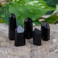 Black Obsidian Mini Points on a wooden surface with leaves in the foreground - Down to Earth