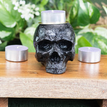 Load image into Gallery viewer, Black Skull Candle Holder with candle tealight front facing displayed on a styled background - Down To Earth
