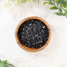 Load image into Gallery viewer, Black Tourmaline Chip 1LB top down with plants on a styled background - Down To Earth
