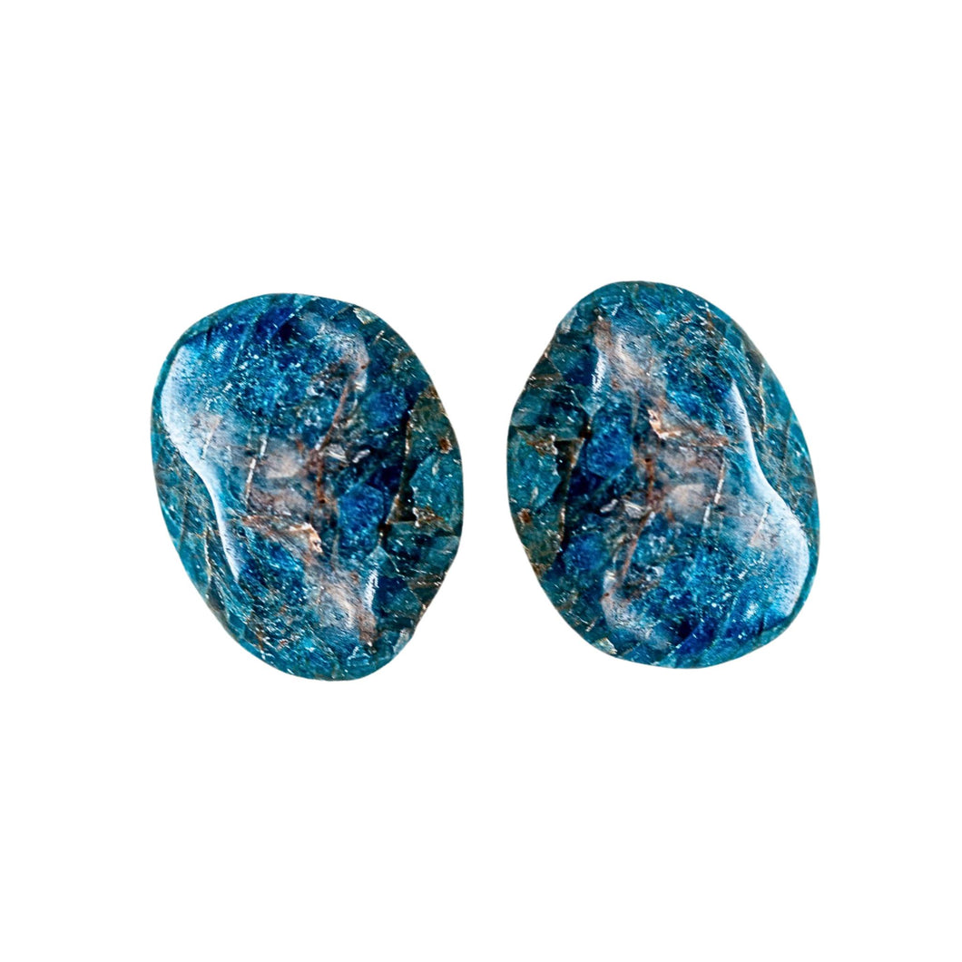 Pictured here is two Blue Apatite palm stones. Each is approximately 1 to 2 inches long. Blue Apatite is a deep blue color with some streaks of brown. - Down to Earth.