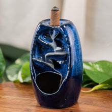 Load image into Gallery viewer, "Blue Ceramic Backflow Burner on a wooden surface with green foliage in the background," - Down to Earth.
