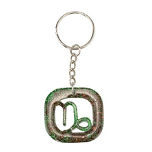 Load image into Gallery viewer, Capricorn Glitter Resin Keychain on a white background - Down To Earth
