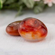 Load image into Gallery viewer, Carnelian Palm Stone on a white cloth - Down to Earth
