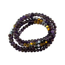 Load image into Gallery viewer, "Stack of beaded bracelets with purple, gold, and silver beads on a white background," - Down to Earth.

